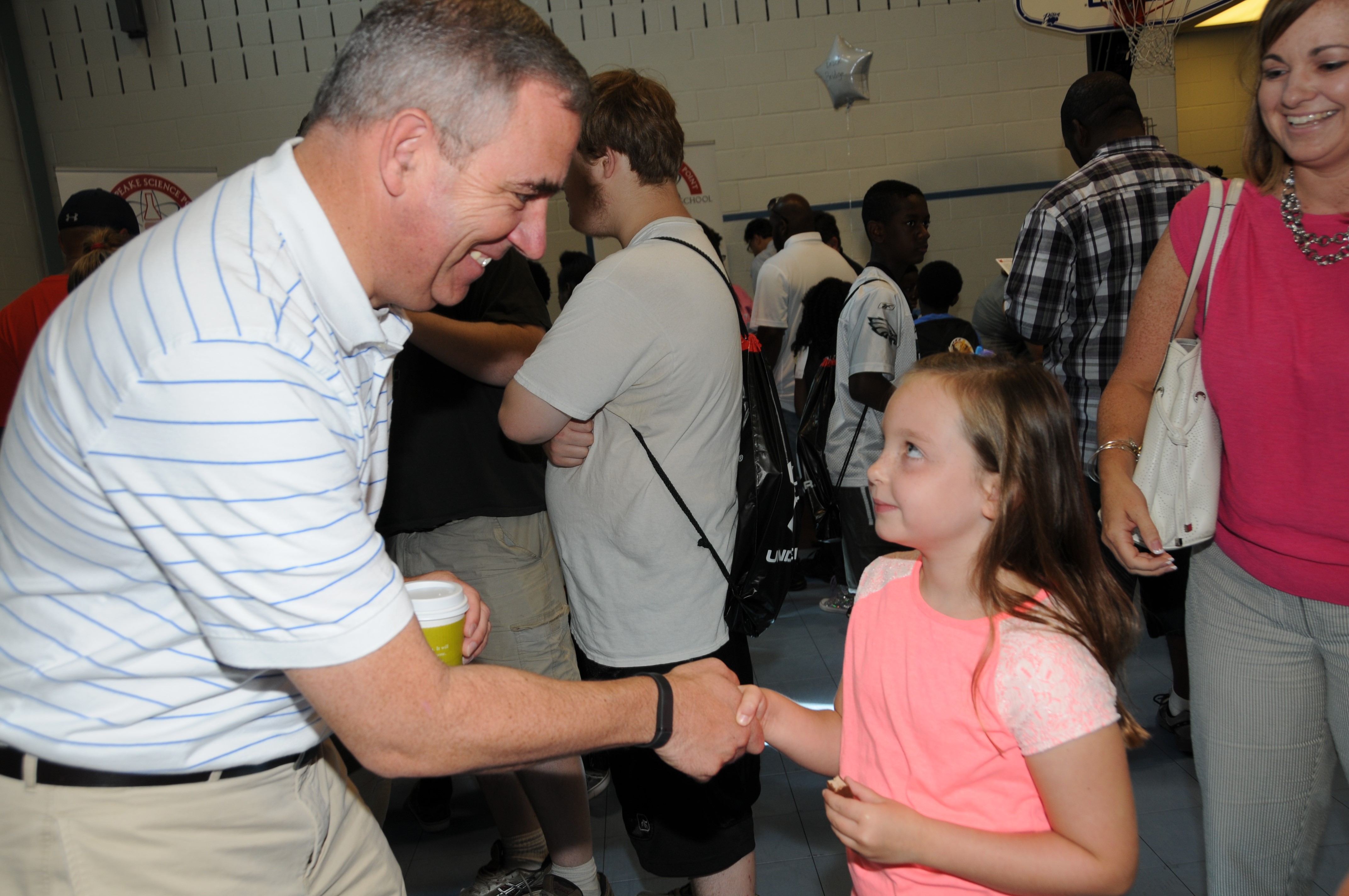 Dr. Arlotto shaking hands with a young AACPS student
